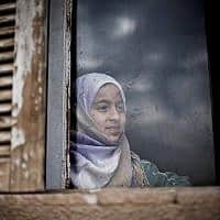 נערה סורית מביטה בחלון בית בקמישלי (צילום: AP Photo/Manu Brabo)