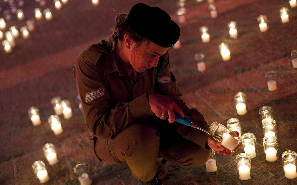 חיילת מדליקה נרות לזכר חללי צהל בטקס יום הזיכרון