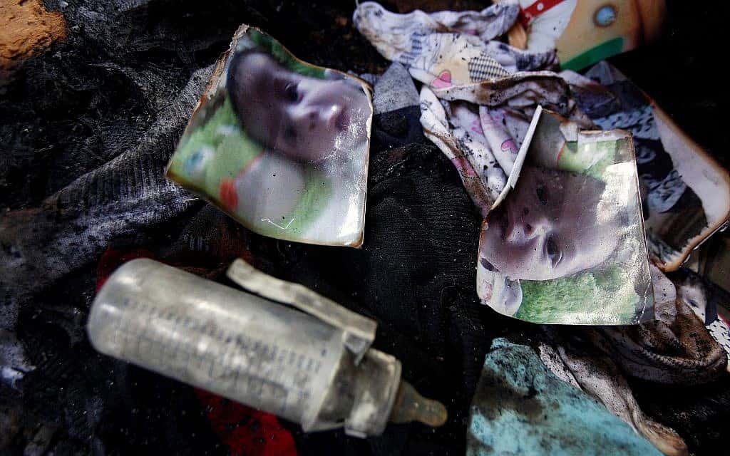 שאריות תמונתו של עלי דוואבשה מוטלות על רצפת הבית השרוף בפיגוע הטרור היהודי בכפר דומא, יולי 2015 (צילום: AP Photo/Majdi Mohammed)