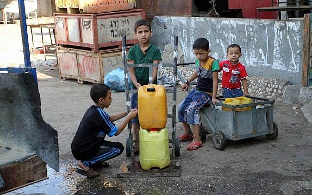 ילדים בעזה ממלאים מיכלי מים, 2015 (צילום: Abed Rahim Khatib / Flash 90)