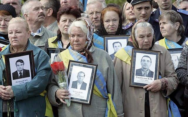 האלמנות של קורבנות צ&#039;רנוביל עם התמונות של בעליהן שמתו לאחר פעולות הניקוי של הפיצוץ הגרעיני בצ&#039;רנוביל ב-1986, באנדרטה לקורבנות צ&#039;רנוביל בבירת אוקראינה, קייב, 26 באפריל, 2008 (צילום: AP\ אפרם לוקצקי)