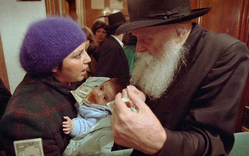 הרבי מלובביץ', מנחם מנדל שניאורסון, ב-1992, מייעץ לאמא צעירה לפני שתקבל ממנו דולר (צילום: AP Photo)