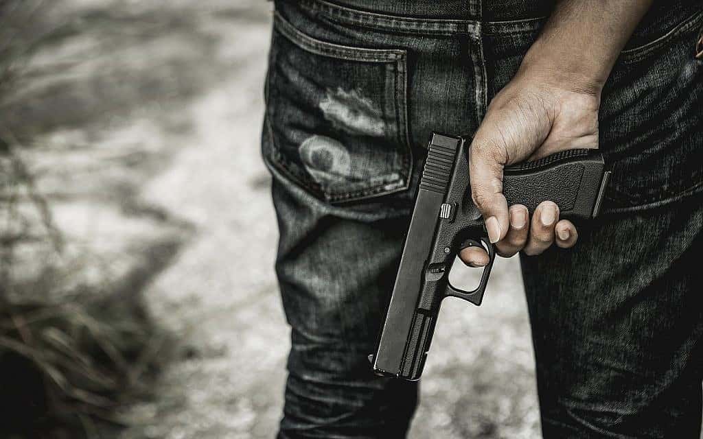 גבר נושא אקדח, אילוסטרציה (צילום: JumlongCh/iStock)