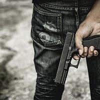 גבר נושא אקדח, אילוסטרציה (צילום: JumlongCh/iStock)