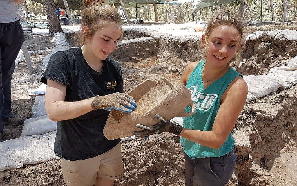 מתנדבות מציגות כד חרס מחירבת א-רעי, אותה זיהו ארכאולוגים בתור ציקלג התנ"כית (צילום: Excavation expedition to Khirbet a-Ra‘i)