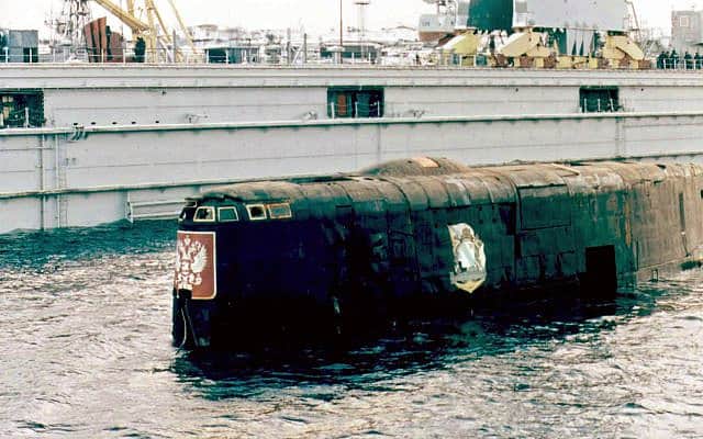 מגדל הפיקוד של הצוללת הגרעינית קורסק נראה מעל פני המים בנמל רוסליאקובו ליד מורמנסק ברוסיה, 23 באוקטובר 2001. ב-12 באוגוסט 2000, בעקבות סדרה של פיצוצים, הצוללת שקעה אל קרקעית ים ברנץ וכל 118 אנשי הצוות שלה נספו. במאמץ חסר תקדים, שעלה לרוסיה כ-65 מיליון דולר, חרטום הצוללת, שנהרס בפיצוצים, הוסר, ושרידי הצוללת, במשקל 9,000 טונות, הורמו אל פלטפורמת שינוע והועברו אל מזח יבש בנמל רוסליאקובו (צילום: AP/מאגר, ארכיון)