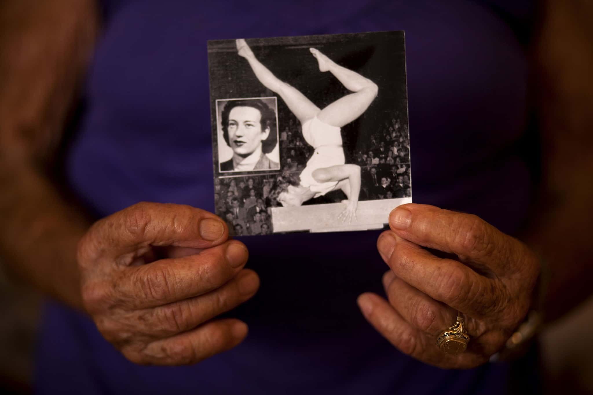 ידיה של אגנס קלטי אוחזות תמונה שלה כמתעמלת צעירה (צילום: AP Photo/Oded Balilty)