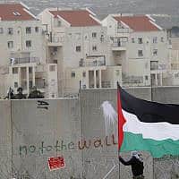a protester waves a Palestinian flag in front of Israeli troops during a protest against Israel's separation barrier, between the West Bank village of Bilin and the Jewish settlement of Modiin Illit, near Ramallah (צילום: AP Photo-Majdi Mohammed)