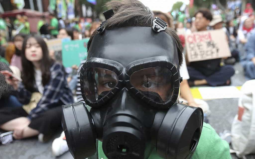 An elementary school student wears a gas mask during a rally demanding action in halting the climate crisis in Seoul, South Korea, Saturday, Sept. 21, 2019. Hundreds of activists attended a rally as a part of global climate strike ahead of a U.N. climate summit in New York (צילום: AP Photo/Ahn Young-joon)