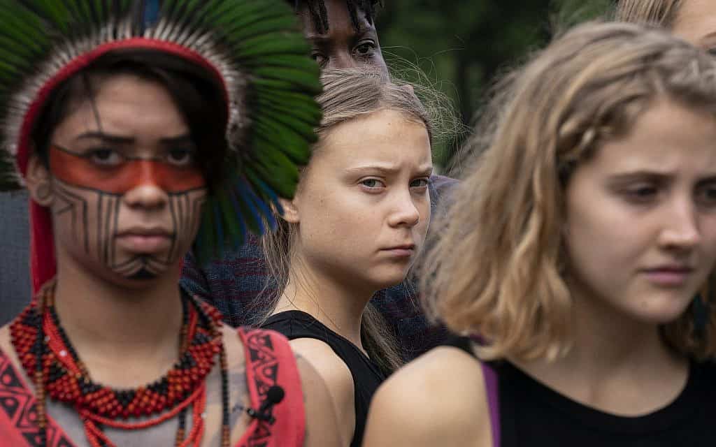 Swedish activist Greta Thunberg, center, who has called on world leaders to step up their efforts against global warming, stands with indigenous people of the Americas and others, during remarks by Sen. Ed Markey, D-Mass., chairman of the Senate Climate Change Task Force, at a news conference at the Capitol in Washington, Tuesday, Sept. 17, 2019 (צילום: AP_Photo-J. Scott Applewhite)