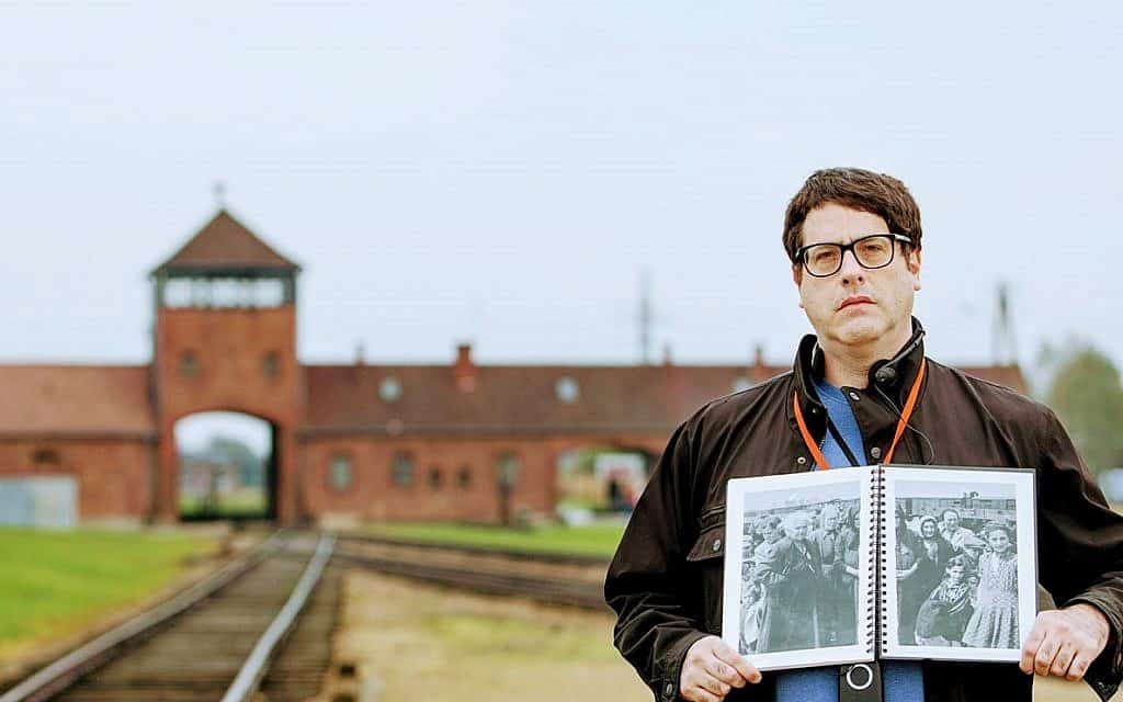 מאט לייבוביץ' באושוויץ-בירקנאו, מחזיק עותק של "אלבום אושוויץ" שבו מופיעה סבתו בלה (ביילה) סולומון, אוקטובר 2017 (צילום: אלן קאווש)
