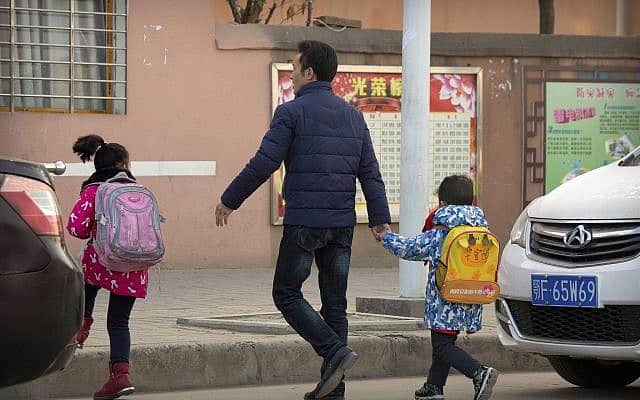 תלמידי בית ספר יסודי בסין בדרכם ללימודים (צילום: Mark Schiefelbein, AP)