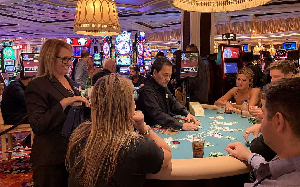 אורלי גרייבס, עומדת מצד שמאל, משוחחת עם לקוחות בשעה שהיא מפקחת על שולחן בלאקג'ק במלון Wynn Las Vegas, 22 בספטמבר, 2019 (צילום: ג'וזפין דולסטן)