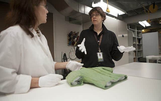 אוצרת מוזיאון ארצות הברית לזכר השואה סוזי סניידר (מימין) מטפלת בסוודר הירוק עם מומחית לשימור (צילום: באדיבות מוזיאון ארצות הברית לזכר השואה)