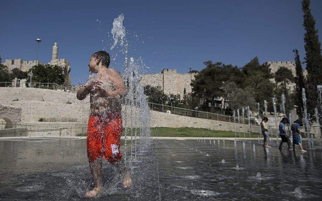 ילדים מתקררים במים ליד מגדל דוד בירושלים (צילום: יונתן סינדל/פלאש90)