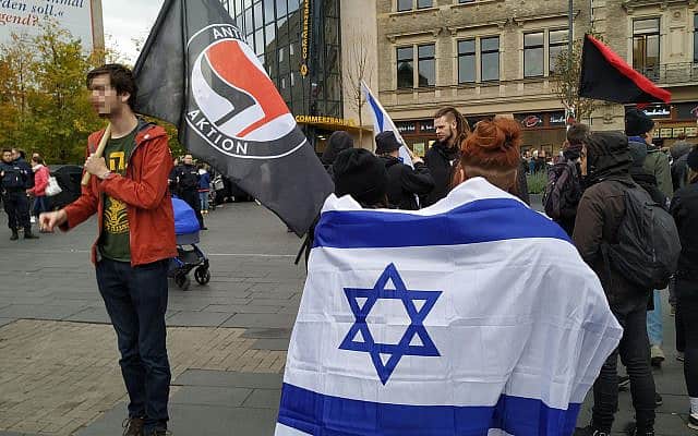 מפגינים עטופים בדגל ישראל וחולצת צה&quot;ל כיכר מרקטפלאץ המרכזית בהאלה, גרמניה, 11 באוקטובר, 2019 (צילום: יעקב שוורץ)