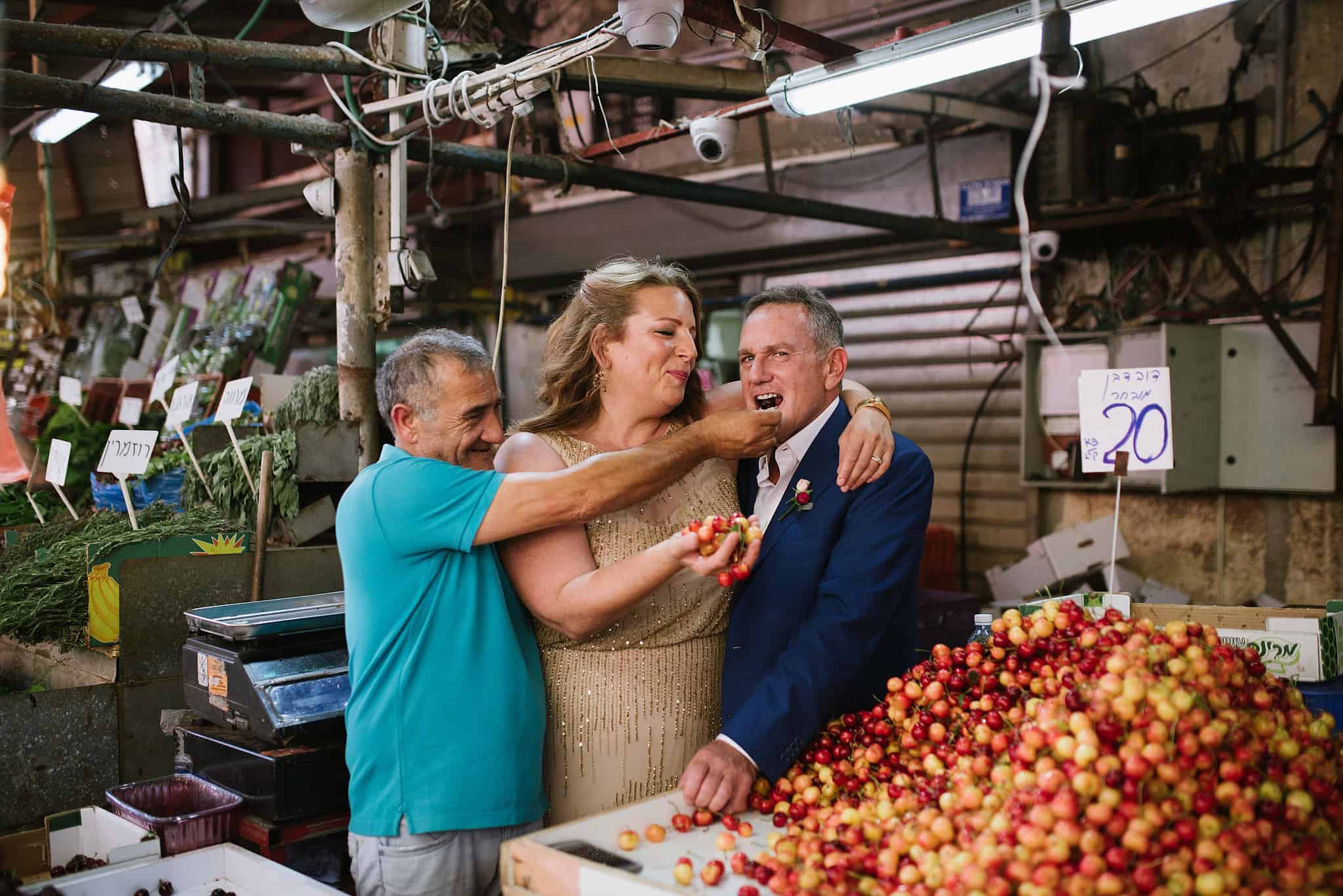 עדינה סוסמן ובעלה ג'יי שופט (מימין) טועמים דובדבנים אצל רוכל בשוק הכרמל ביום חתונתם (צילום: באדיבות עדינה סוסמן)