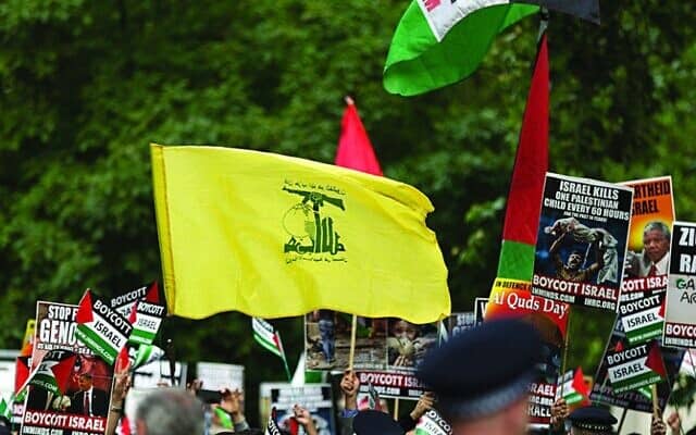 אילוסטרציה: דגל חיזבאללה מונף במהלך עצרת של אל-קודס בלונדון (צילום: סטיב ווינסטון\ דרך Jewish News)