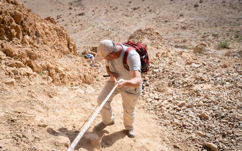 החוקר אורן גוטפלד יורד ממערה 52 באתר הארכיאולוגי בקומראן, 22 בינואר 2019 (צילום: לוק טרס/Times of Israel)