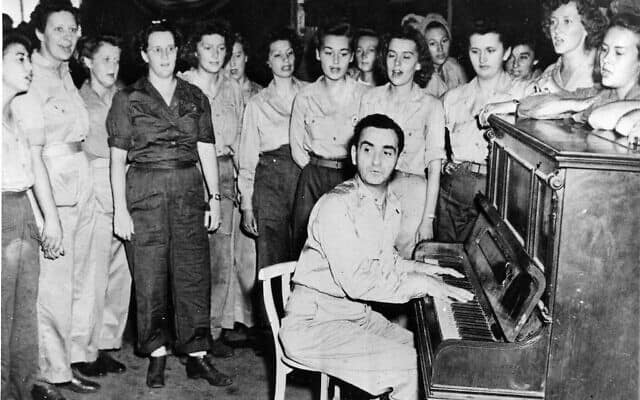 אירווינג ברלין, כותב שירים, נגן פסנתר וזמר, מנגן את אחד משיריו מול חיילות בבסיס חייל האוויר של ארה&quot;ב במטה המזרח הרחוק בהולנדיה, גינאה החדשה ההולנדית, 31 בדצמבר, 1945 (צילום: AP\ צבא ארצות הברית)
