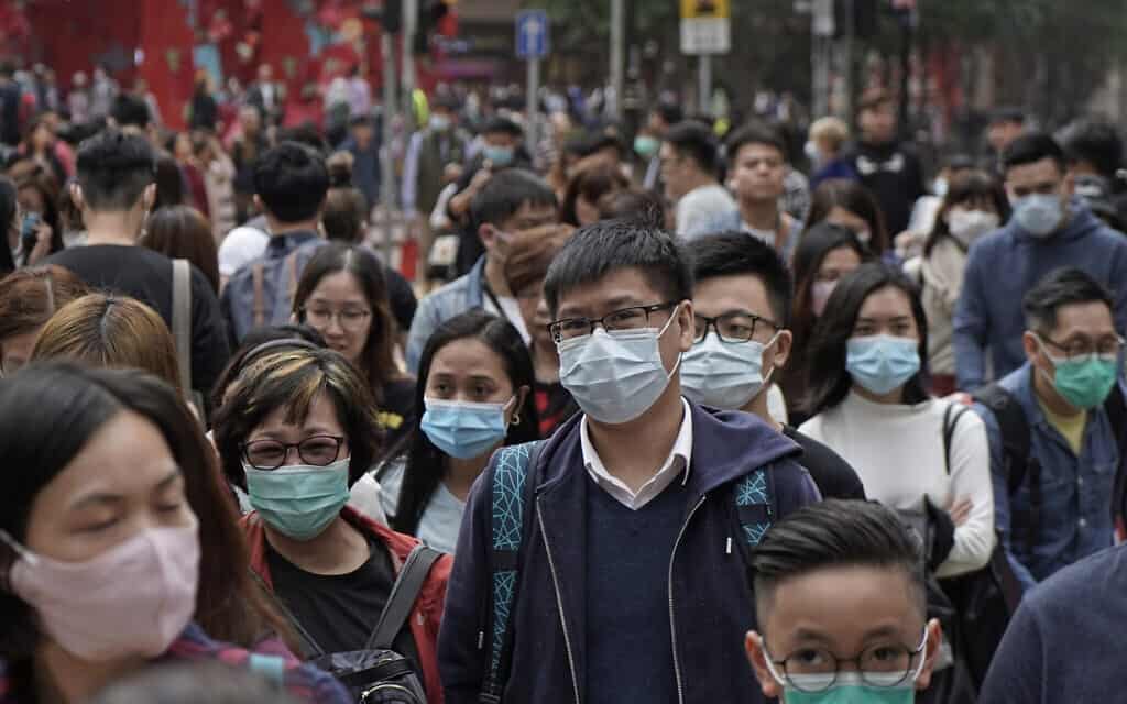 אנשים לובשים מסכות ברחוב בהונג קונג, בעקבות התפרצות מגיפת הקורונה, 24 בינואר 2020 (צילום: AP Photo/Kin Cheung)