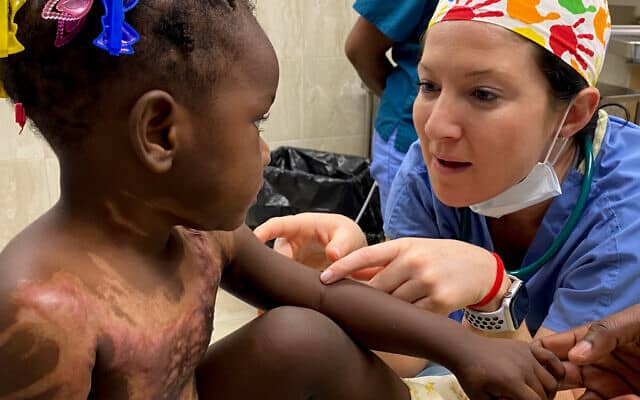 האחות האמריקאית קארי גלאגר מעודדת ילדה נפגעת כוויות לפני ניתוח לייזר במילו, האיטי, ינואר 2020 (צילום: באדיבות Burn Advocates Network)