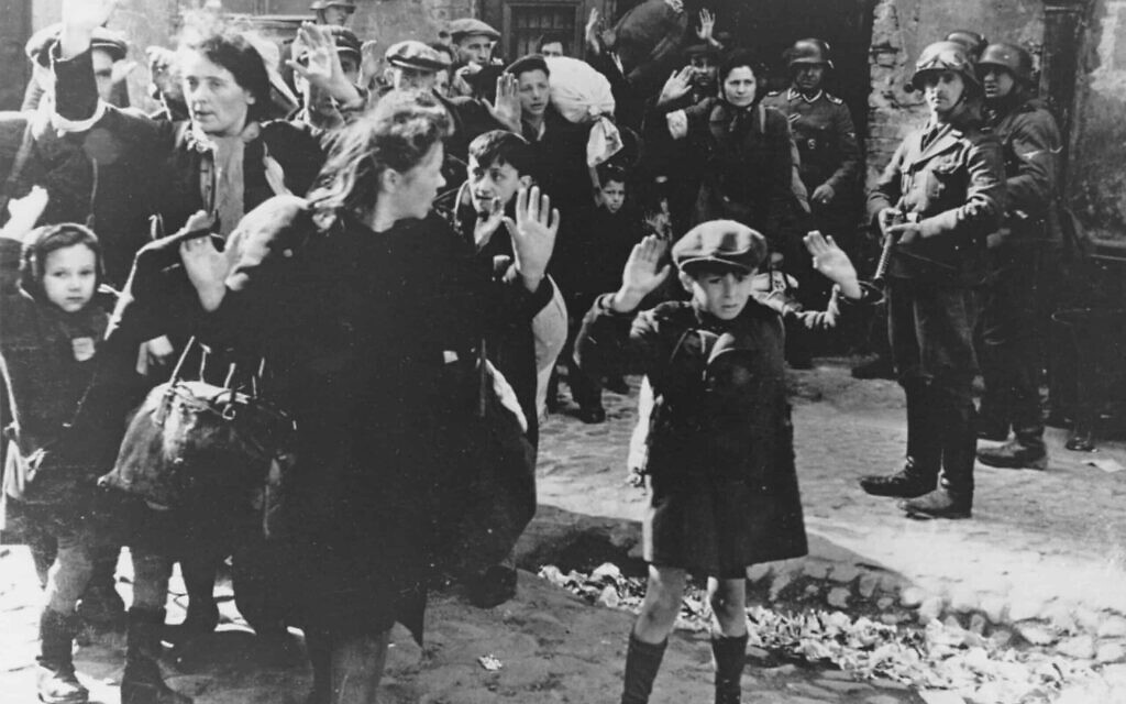 קבוצה של יהודים, ביניהם ילד קטן, מובלים מגטו ורשה על ידי חיילים גרמנים, 19 באפריל, 1943 (צילום: AP)