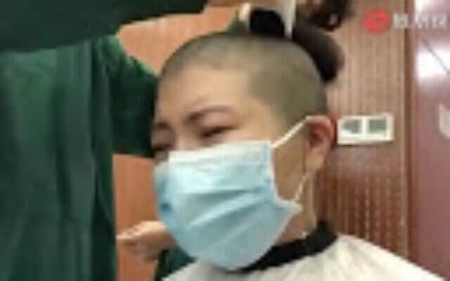 צילום מסך מתוך סרטון שפורסם בסין ובו אחיות מגלחות את שיער ראשן כדי לשמור על היגיינה בעת הטיפול בחולים שנדבקו בקורונה 