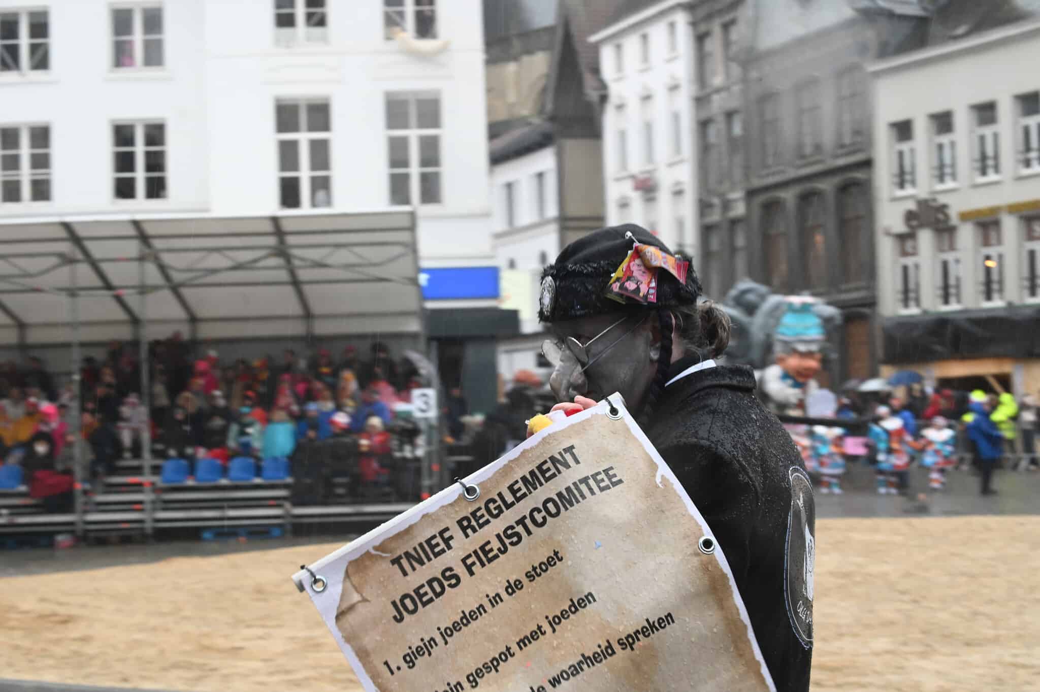 גבר עם אף מלאכותי מעוקל, נושא שלט המזהיר, &quot;אסור לספר את האמת על היהודים&quot; בתהלוכה השנתית של הקרנבל באלסט שבבלגיה, 23 בפברואר 2020 (צילום: כנען ליפשיץ)
