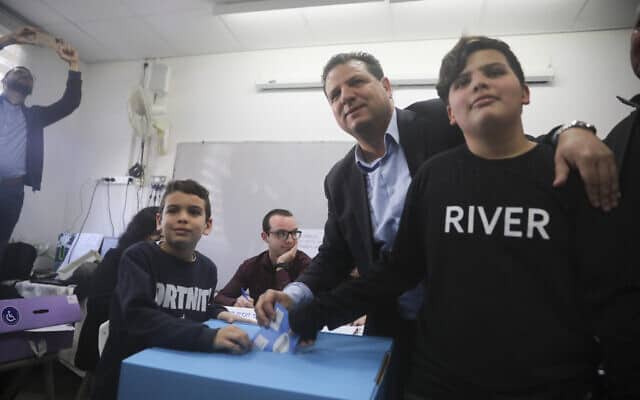 איימן עודה מצביע בבחירות לצד ילדיו בחיפה, הבוקר (צילום: Mahmoud Illean, AP)