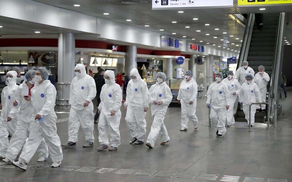 אנשי צוות רפואי ברוסיה מגיעים לנמל התעופה כדי לבצע בדיקות קורונה לנוסעים המגיעים ממדינות זרות (צילום: AP Photo/Pavel Golovkin))