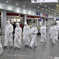 אנשי צוות רפואי ברוסיה מגיעים לנמל התעופה כדי לבצע בדיקות קורונה לנוסעים המגיעים ממדינות זרות (צילום: AP Photo/Pavel Golovkin))