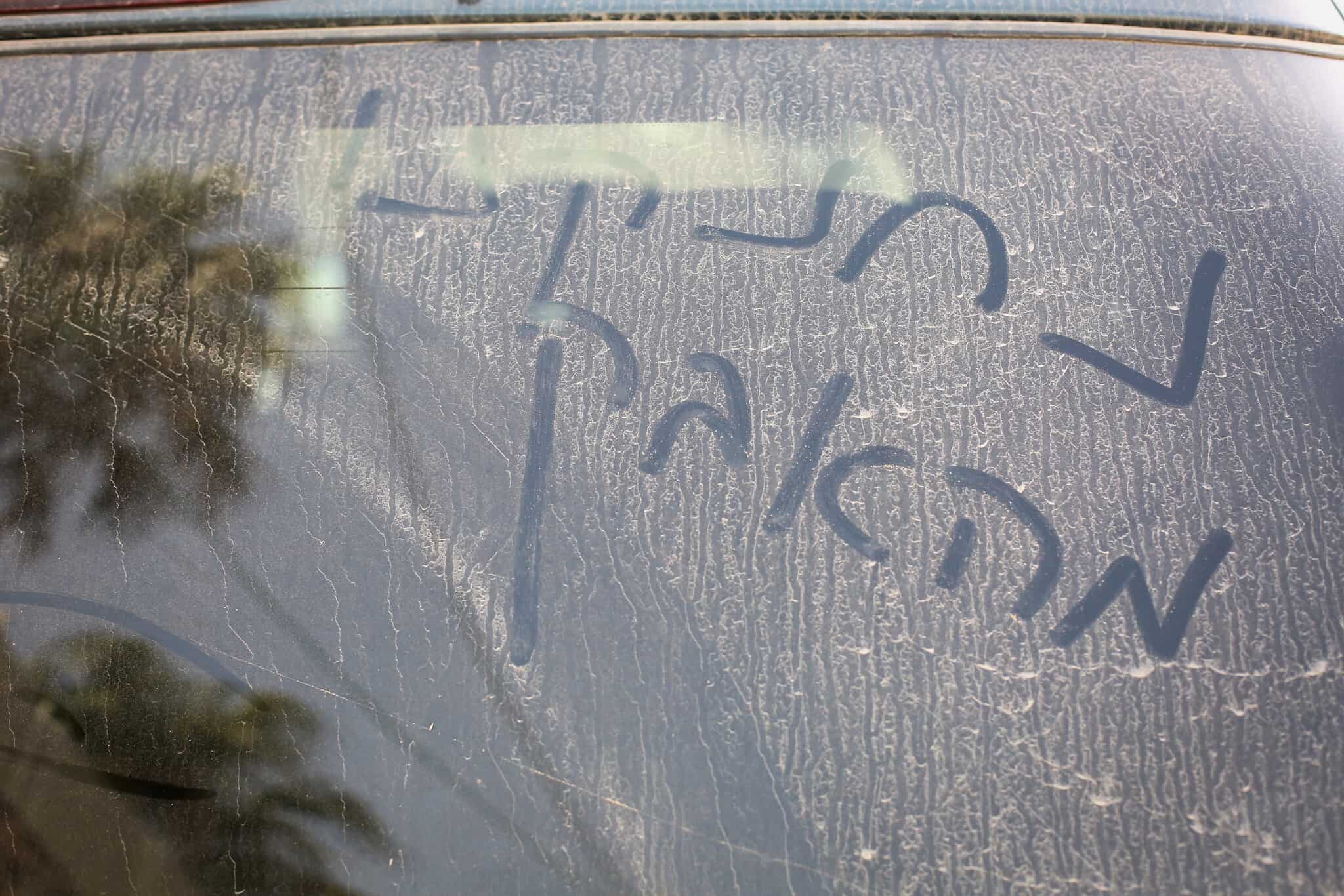 &quot;נחנקנו מאבק&quot; נכתב על שמשת מכונית מכוסה באבק ב-2017 (צילום: דוד כהן/פלאש90)