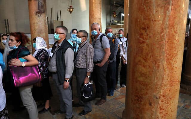 תיירים העוטים מסכות מגן בכנסיית המולד בבית לחם, 5 במרץ 2020 (צילום: Wissam Hashlamoun/Flash90)