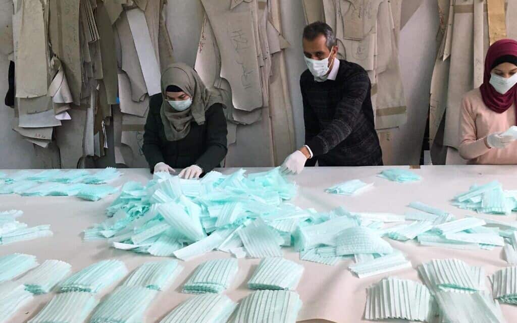 פועלים במפעל בחברון מייצרים מסכות עבור השוק הפלסטיני (צילום: באדיבות אחמד זוע'ייר)