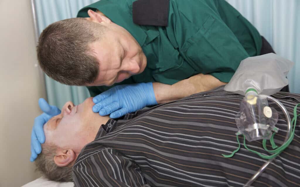 פרמדיק מבצע פעולות החיאה בחולה שהתמוטט (צילום: iStock Henfaes)