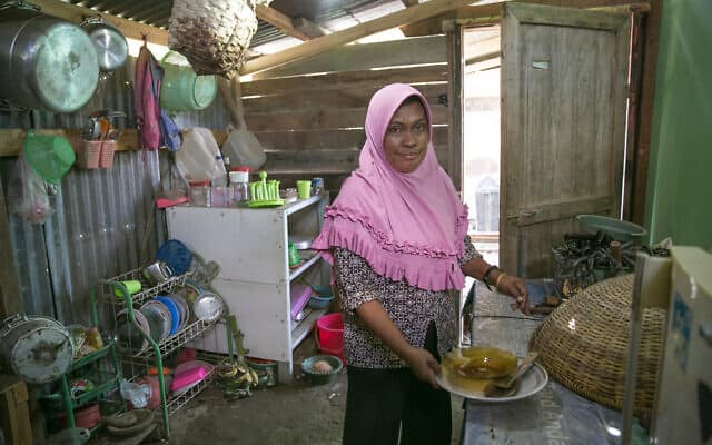 אישה מבשלת במטבח הקהילתי במחנה העקורים בפאלו, אינדונזיה. הגישה המוגבלת לשירותי רפואה והמגורים בדיור ארעי וצפוף מעמידים את הקהילה שלה בסיכון גבוה לחלות בקוביד-19 (צילום: אליסון ג&#039;ויס/AJWS)