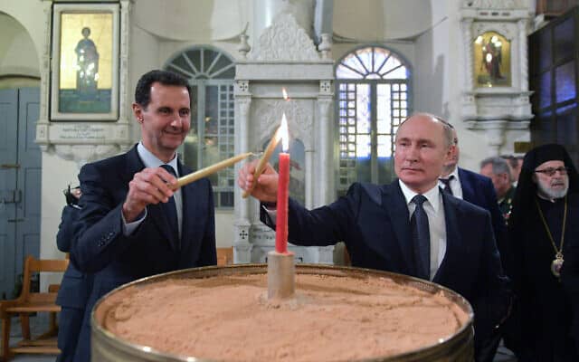 ולדימיר פוטין ובשאר אל אסד מדליקים נר בכנסיה האורתודוקסית בדמשק, בעת ביקורו של נשיא רוסיה שם, ב-7 בינואר 2020 (צילום: Alexei Druzhinin, Sputnik, Kremlin Pool Photo via AP)
