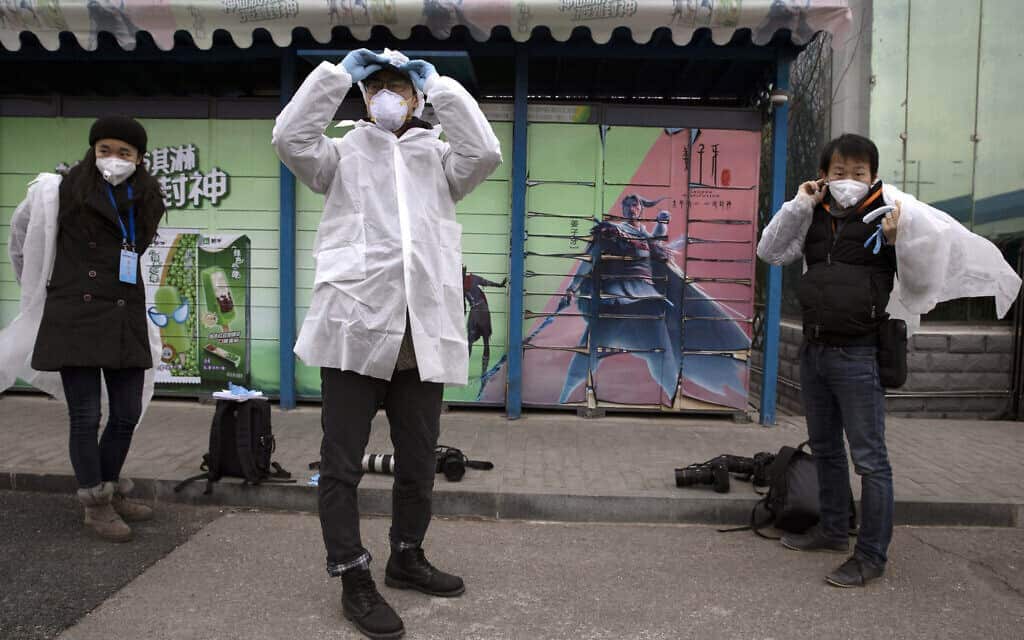 עיתונאים מתמגנים לפני סיור במפעל סיני, בשיא משבר הקורונה שם (צילום: AP Photo/Ng Han Guan)
