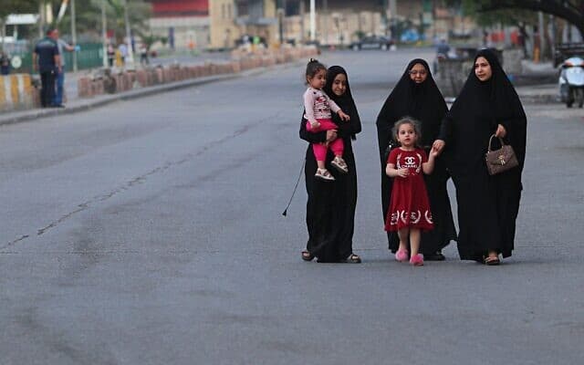 מגפת הקורונה בעיראק: קבוצת נשים וילדות ברחוב כמעט-שומם בבגדד (צילום: AP Photo/Hadi Mizban)