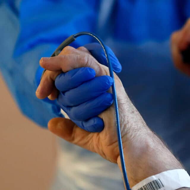 סיוע רפואי לקשיש החולה בקורונה (צילום: AP Photo/Petr David Josek)
