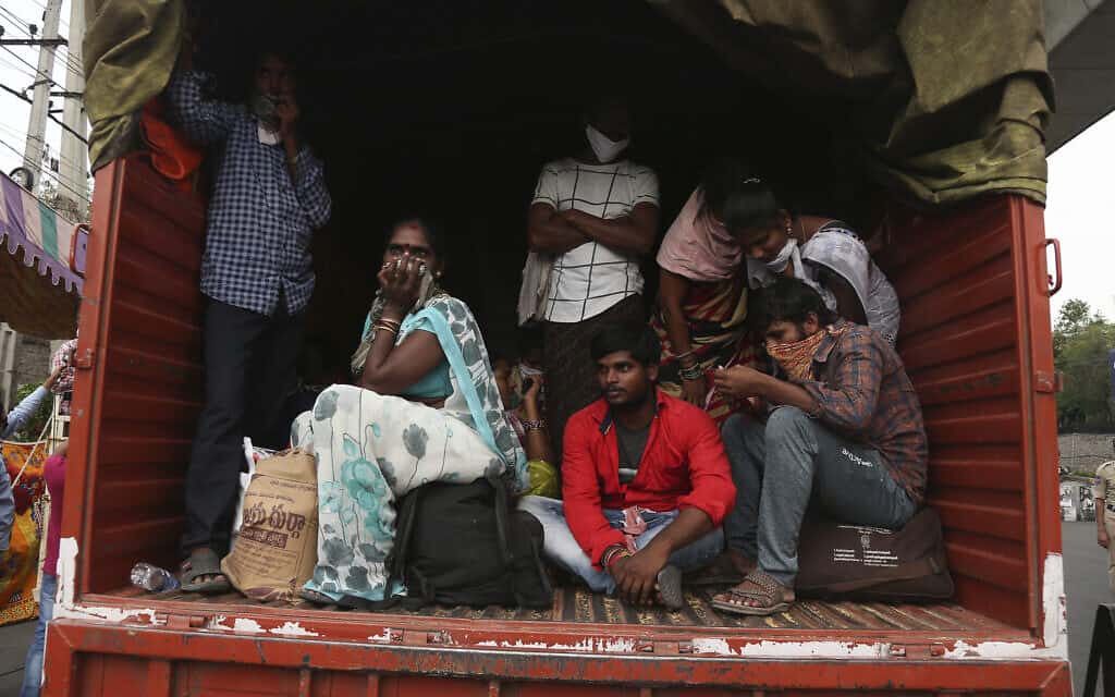 עובדים הודים שנעצרו בדרכם לביתם והועלו על משאית של הממשלה – בדרך למחנה הסגר. 14 באפריל 2020 (צילום: AP Photo/Mahesh Kumar A)