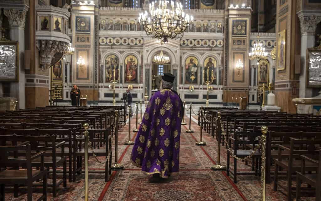 הכומר היווני בטקס דתי ללא נוכחות קהל המאמינים בקתדרלה באתונה, יוון 2020 (צילום: AP Photo/Petros Giannakouris)