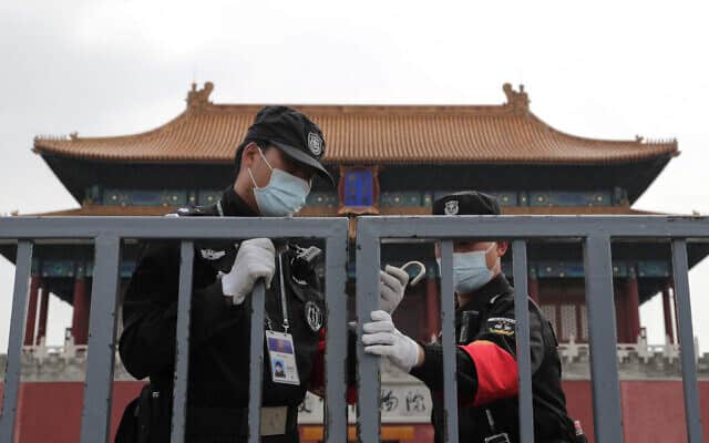 עידן הקורונה: שוטרים בעיר האסורה בסין (צילום: AP Photo/Andy Wong)