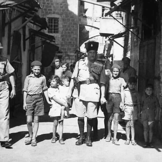 קצין משטרה בריטי מסייע לילדים יהודיים לחצות בבטחה את רחובות ירושלים, אוקטובר 1938 (צילום: AP Photo/James Mills)