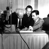  דוד בן גוריון חותם על מגילת העצמאות ב-14 במאי 1948. מימינו, משה שרת (צילום: AP Photo)