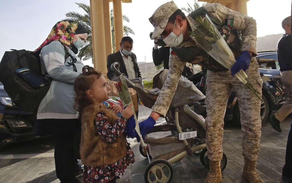 חיילים ירדנים מחלקים פרחים לתושבים שהיו נתונים לסגר ממושך בצד הירדני של ים המלח, 30 במרץ 2020 (צילום: halil Mazraawi/Pool via AP)