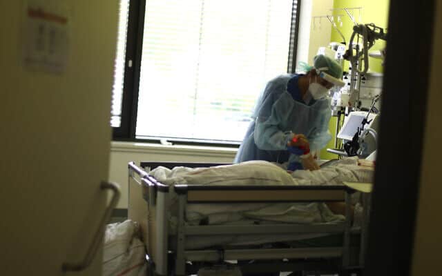 אחות בבית חולים בדיסלדורף, גרמניה, מטפלת בחולה קורונה. 29 באפריל 2020 (צילום: AP Photo/Matthias Schrader)