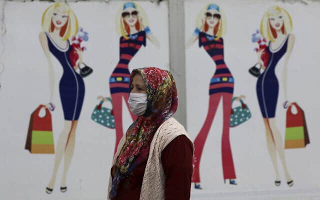 אישה חולפת ליד חנות בגדים סגורה בטורקיה, השבוע (צילום: AP Photo/Ali Unal)
