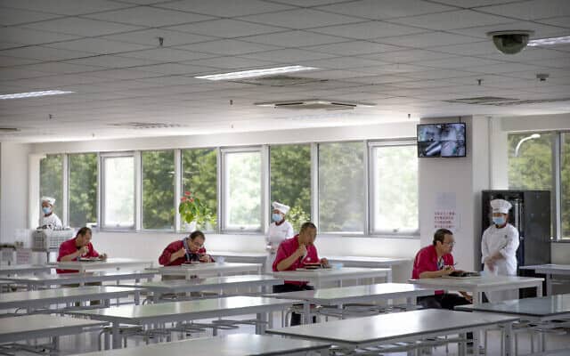 עובדי מפעל מתרגלים ריחוק חברתי בזמן שהם אוכלים ארוחת צהריים (צילום: AP Photo/Mark Schiefelbein)
